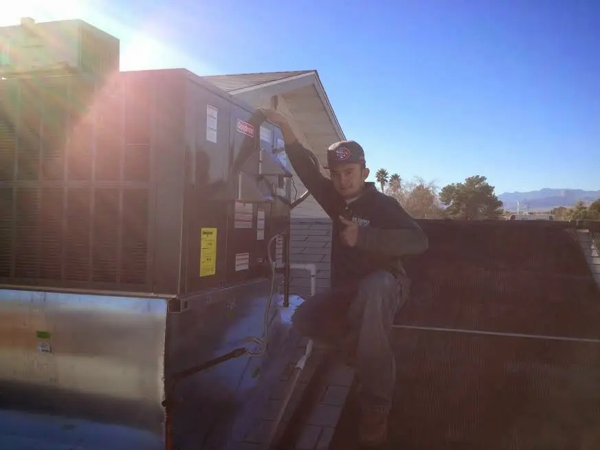 HVAC technician performing Air Duct Cleaning on a rooftop unit in Mukilteo
